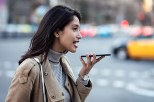 Woman using a smartphone voice search to find local business results and learn how to rank for near me searches